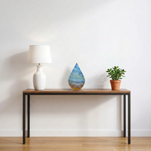 Load image into Gallery viewer, Computer-generated illustration: Nao Yamamoto Unicorn Cloud blue teardrop art glass sculpture on a console table beside a white lamp and a small plant