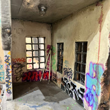 Load image into Gallery viewer, Interior room detail with multi-pane windows, painted walls, and graffiti markings.