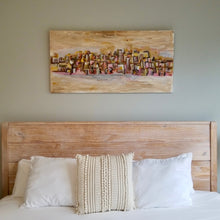 Load image into Gallery viewer, “Tan City” by Scotty Wilson shown installed above a bed, demonstrating scale and interior setting.