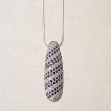 Load image into Gallery viewer, 14k gold sapphire and diamond pendant necklace on a bright white plaster background
