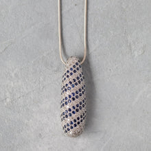 Load image into Gallery viewer, 14k gold sapphire and diamond pendant necklace on a gray textured background
