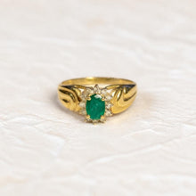 Load image into Gallery viewer, 14k gold emerald and diamond ring on a cream plaster background
