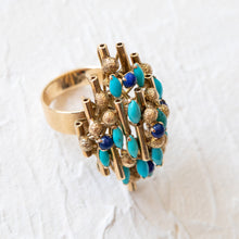 Load image into Gallery viewer, Angled side view of a 14k yellow gold statement ring showing textured gold spheres and vertical bars set with turquoise and lapis.

