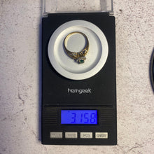 Load image into Gallery viewer, 14K gold emerald and diamond ring on digital scale showing weight
