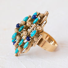 Load image into Gallery viewer, Angled view of the gold turquoise and lapis ring showing the unique vertical bar setting and gemstone cluster.
