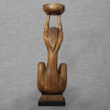 Load image into Gallery viewer, Front view of carved wooden sculpture of a seated woman holding a raised vessel overhead.
