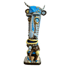 Load image into Gallery viewer, A paper mache sculpture by artist Michael Firkaly, depicting a stylized figure with a blue face, wearing a brown suit with decorative elements.

